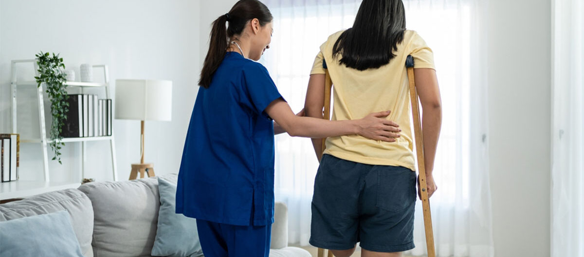 asianfemalelegamputeedoingphysiotherapywithsupportfromnurse