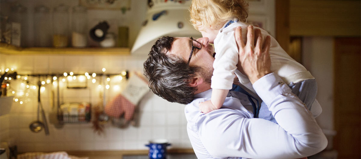businessmancominghomefromworkkissinghislittleson