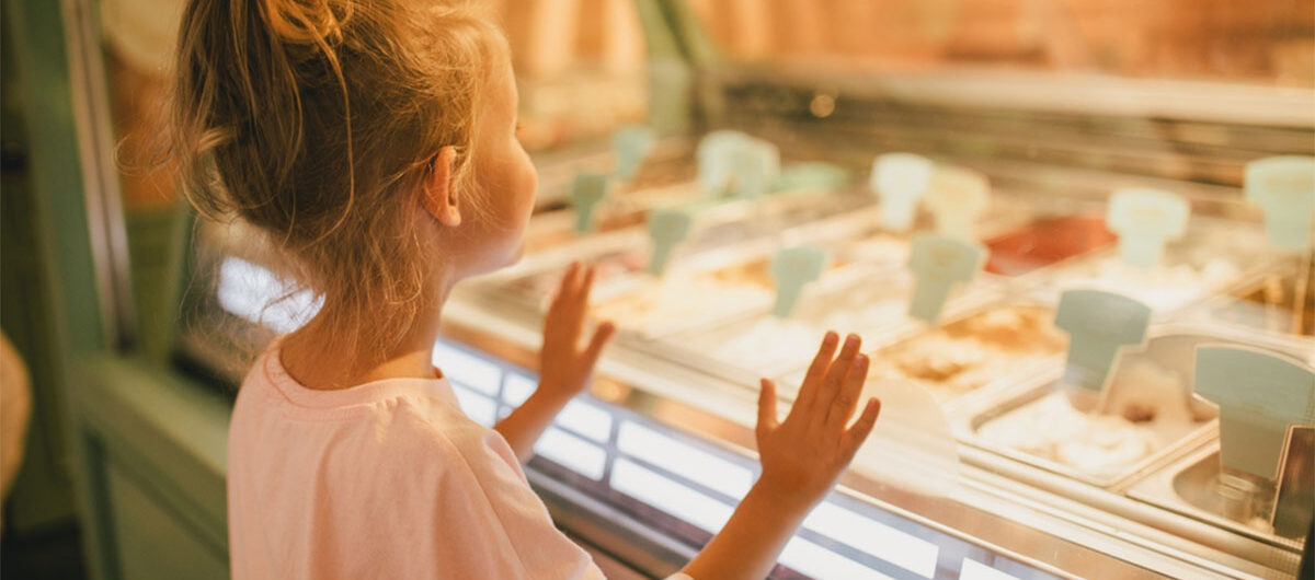 cutelittlegirlstandingnearice-creamshopchoosingice-cream