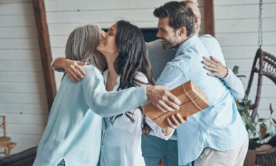 cheerfulseniorparentsmeetingyoungcoupleinsidethehouse