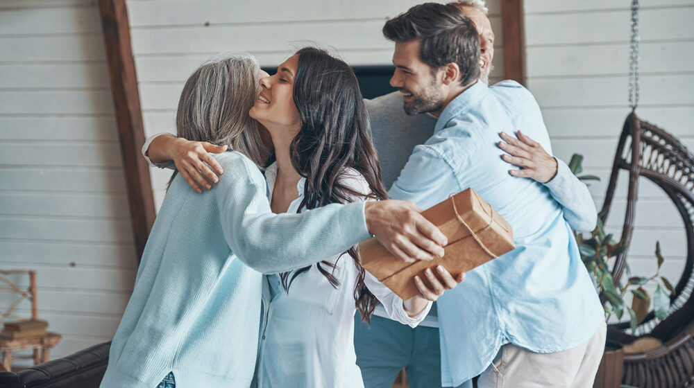 cheerfulseniorparentsmeetingyoungcoupleinsidethehouse